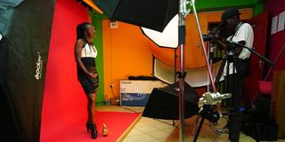 A student at Melody House Music & Film Academy practices studio lighting and portrait photography in a fully equipped media lab.